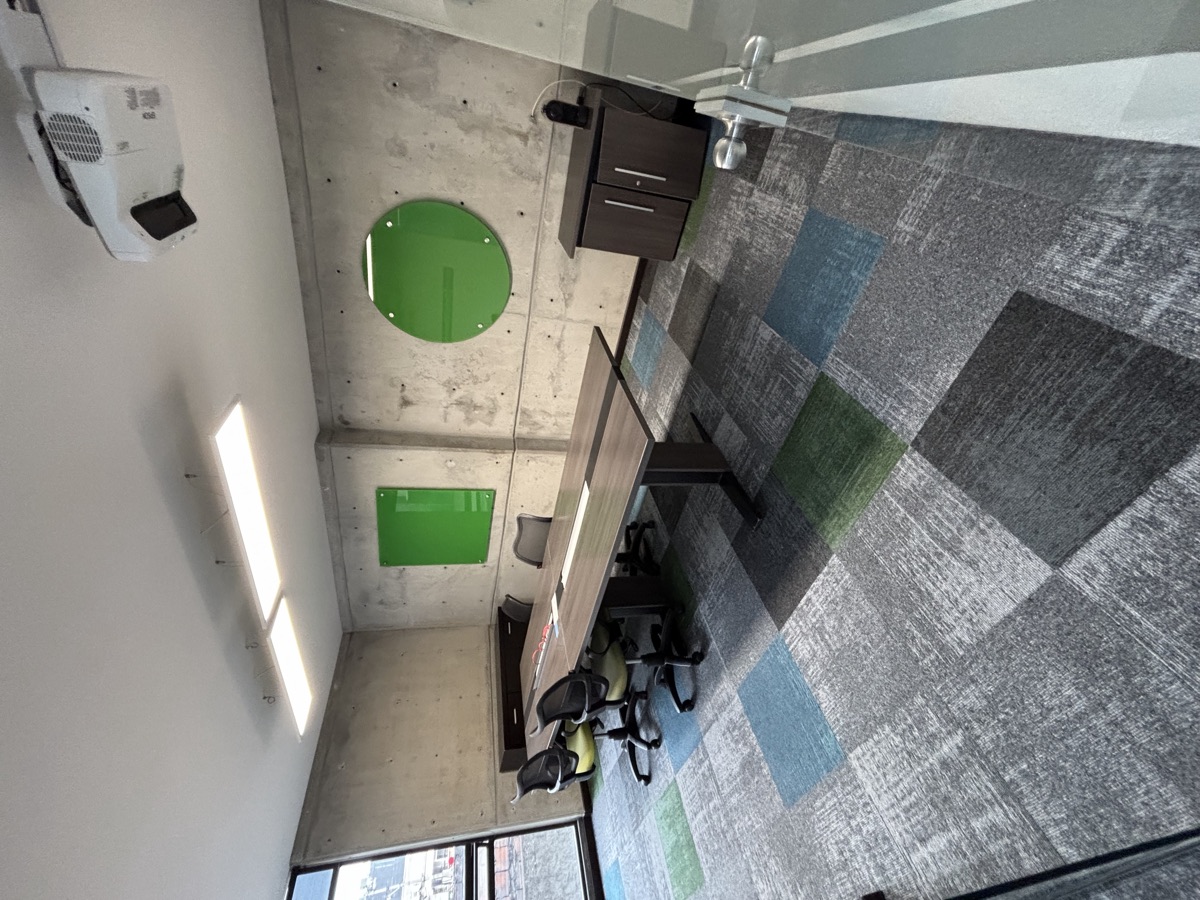 Sala de juntas con alfombra modular patchwork en verde, azul y gris