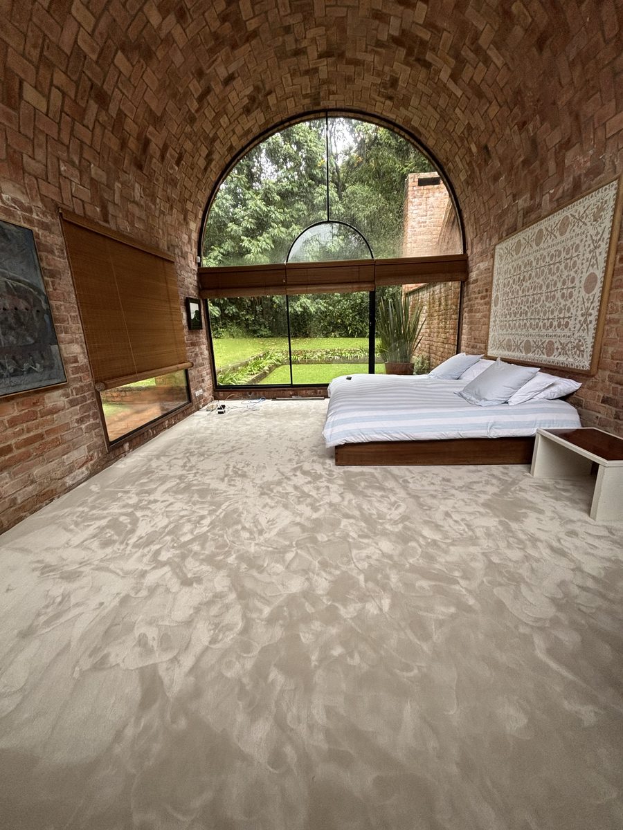 Habitación con techo de ladrillo abovedado, cama y alfombra en rollo Mila