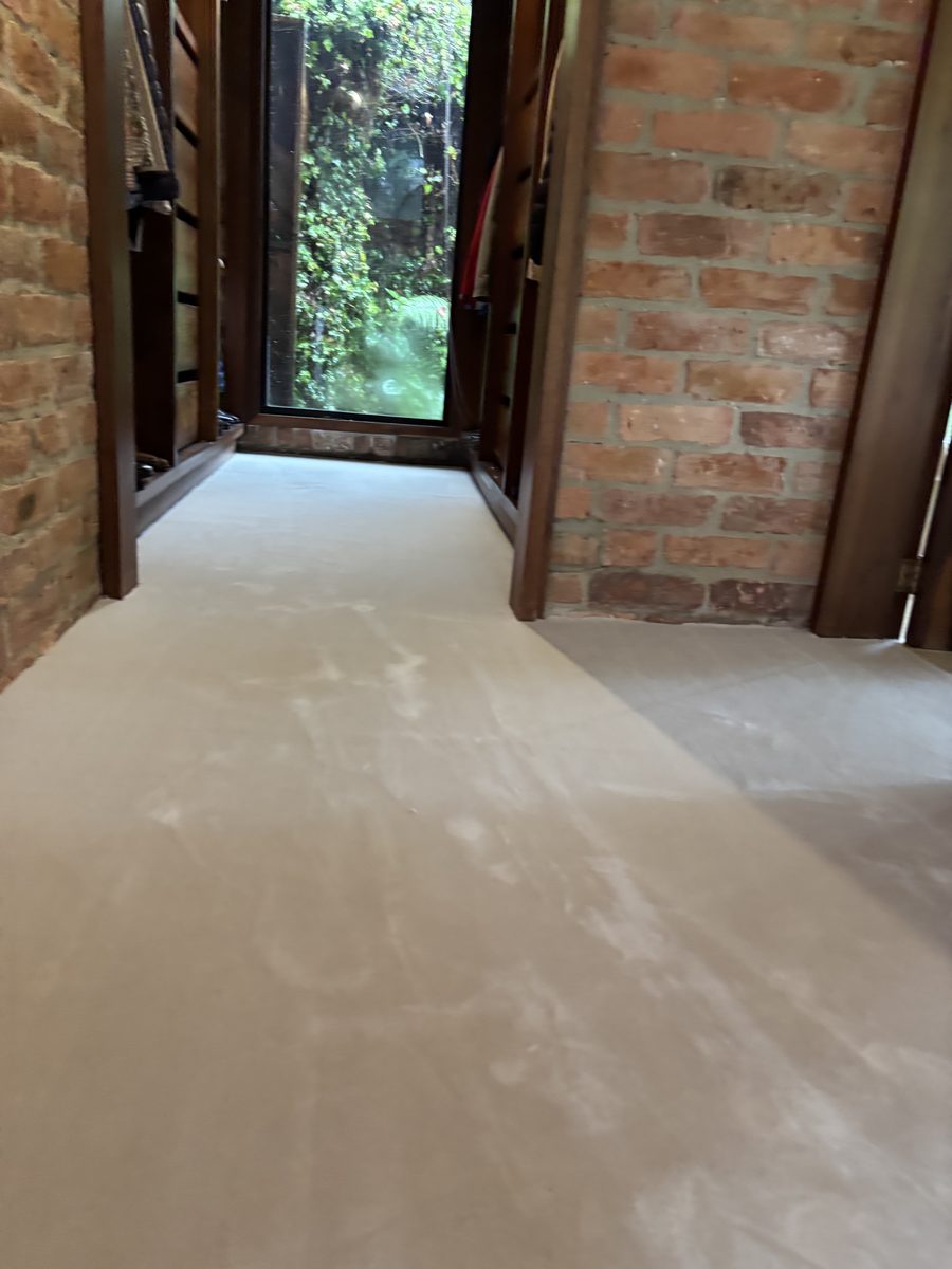 Corredor de ladrillo con ventana al jardín y alfombra en rollo Mila